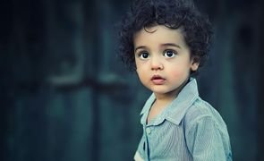 menino de cabelo cacheado e camisa social