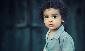 menino de cabelo cacheado e camisa social