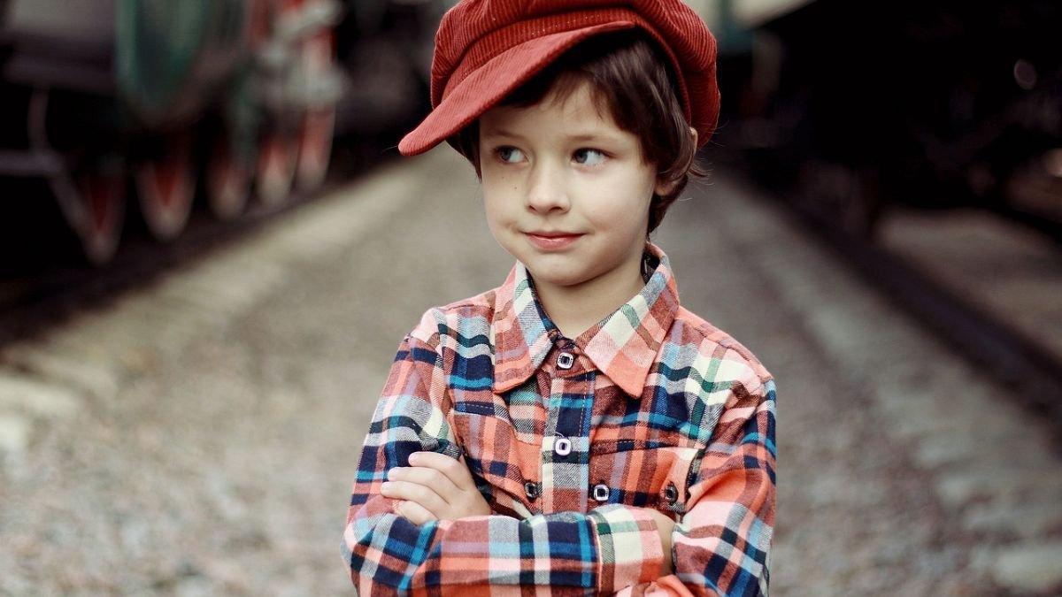 menino de chapeu vermelho e camisa listrada