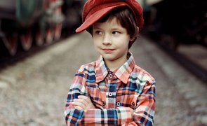 menino de chapeu vermelho e camisa listrada