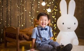 menino rindo com coelho ao fundo