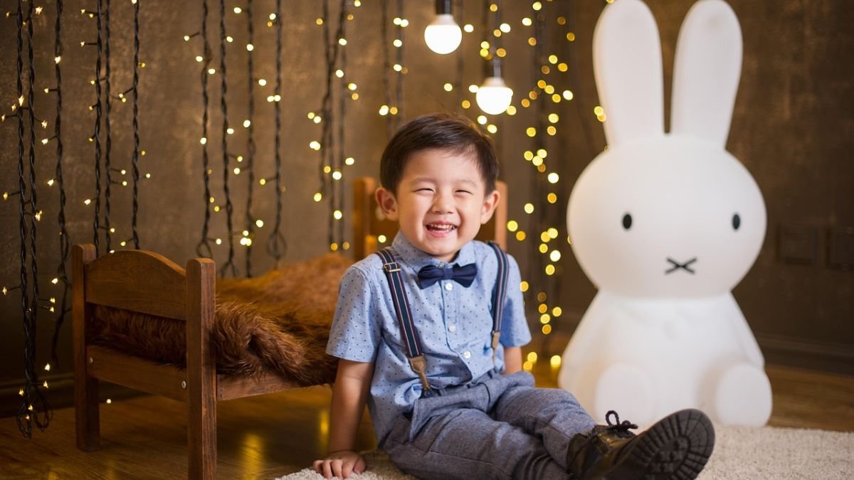 menino rindo com coelho ao fundo